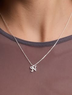 Introducing our Sterling Silver Letter Necklace, a delicate expression of personal style. This Tiny Initial Necklace features the letter "N," elegantly crafted to adorn your neckline with subtle charm. Plated in lustrous gold, this Dainty Initial Necklace adds a touch of sophistication to any outfit. Embrace individuality with this Small Monogram Necklace, a timeless accessory that speaks volumes in its simplicity. 🌸  Each piece is meticulously crafted, offering a unique and intimate touch. Ide Necklaces Initial Letter, N Initial Necklace, N Necklace, Silver Letter Necklace, Bracelet Stands, Letter Necklace Silver, Initial Necklace Silver, Silver Necklace Simple, Dainty Initial Necklace