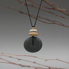 three stones are stacked on top of each other in a circle with a black cord