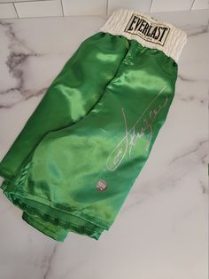 a pair of green shorts with autographs on them