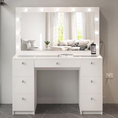 a white vanity with lights on it and a couch in the background