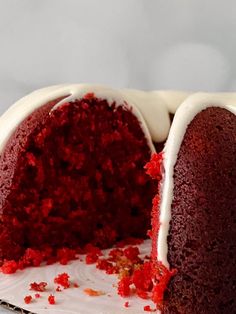 a red velvet bundt cake with white frosting and sprinkles on top