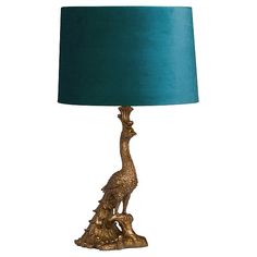 a lamp with a blue shade on it and a bird sitting on top of the base