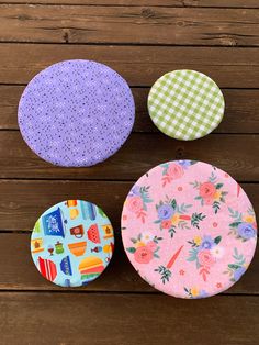 three fabric covered coasters sitting on top of a wooden table