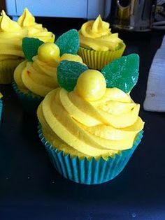 several cupcakes with yellow frosting and green leaves on the top are sitting on a table