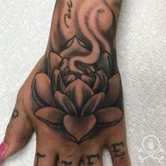 a person's hand with a tattoo on it and a flower in the middle