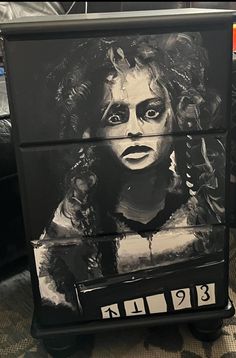 a black and white image of a woman's face painted on a dresser drawer