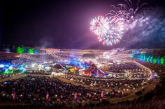 fireworks are lit up in the sky above an outdoor festival