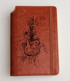 a brown leather notebook with an image of a guitar on it