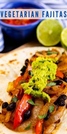 a tortilla with black beans, peppers and guacamole on it