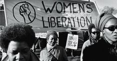 black and white photograph of women protesting in front of a woman's liberation sign