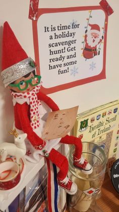 there is a elf that is sitting on top of a shelf next to some books