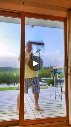 a man standing in front of a sliding glass door with a baseball bat on it