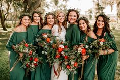 a group of women standing next to each other in green dresses holding bouquets and flowers