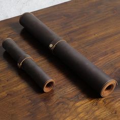 two rolled up yoga mats sitting on top of a wooden table