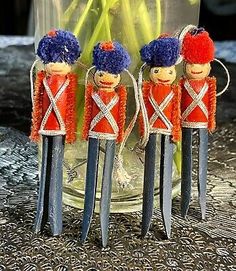 three wooden toy soldiers are standing in front of a vase filled with tulips