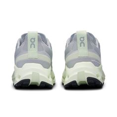 the back view of a pair of grey and white sneakers