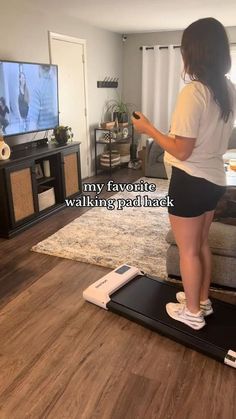 a woman standing on a scale in front of a tv