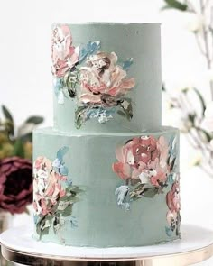 a three tiered cake with flowers painted on it