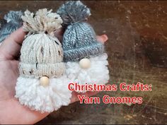 someone is holding three small knitted christmas hats with pom - poms on them