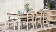 a dining room table and chairs in front of a chalkboard