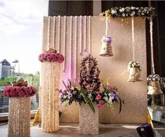 an arrangement of flowers and bells on display in front of a window at a wedding