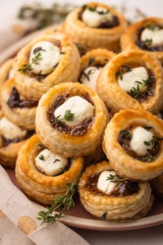 small pastries on a plate topped with cheese and olives are ready to be eaten