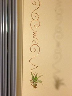 an air plant hanging from the side of a wall next to a radiator