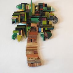 a tree made out of wooden pieces on a wall with a clock in the middle