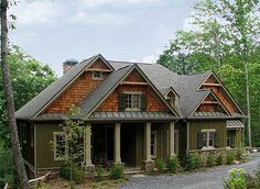 a house in the woods with lots of trees and flowers on the front lawns