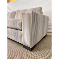 a striped couch sitting on top of a carpeted floor