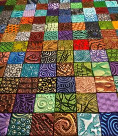 a colorful quilt with many different designs on it's sides and the colors are multi - colored