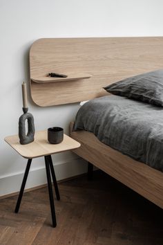 a bed with a wooden headboard and night stand next to it on a hard wood floor