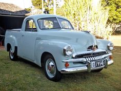 an old car is parked in the grass