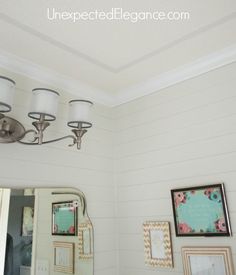 a bathroom with pictures on the wall and a chandelier hanging from the ceiling