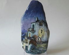 an artistically painted rock with a house on it