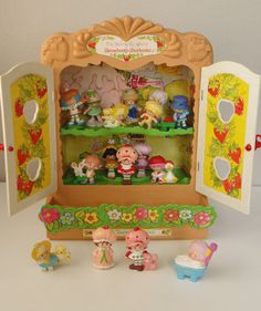 a toy display case filled with little figurines on top of a white table