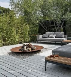 an outdoor living area with couches, tables and fire pit in the foreground