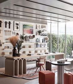 a living room filled with lots of furniture next to a window covered in pictures and plants