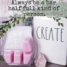 a white container with pink cubes sitting next to a sign that says, always be a bar half full kind of person