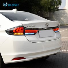 the rear end of a white car parked in a parking lot