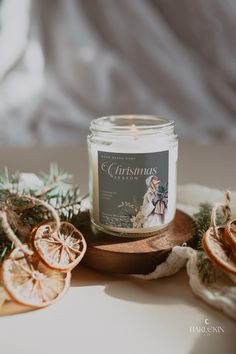 a candle sitting on top of a table next to sliced oranges and pine cones