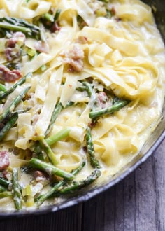 pasta with asparagus, ham and parmesan cheese in a skillet