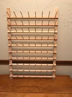 a wooden table topped with a shelf filled with lots of shelves next to a wall