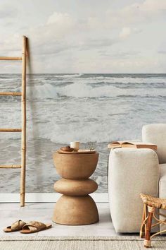 a living room scene with focus on the ocean wallpaper and furniture, along with a ladder in the background