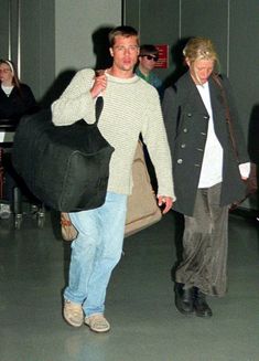 a man and woman walking through an airport