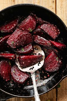 cooked beets in a skillet with a spoon