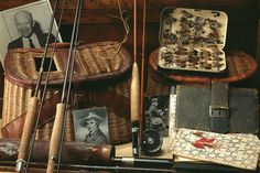 an assortment of fishing equipment including rods, reels and other items in a wicker basket