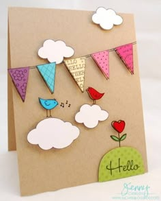 a handmade card with colorful flags and birds hanging from it's sides, on top of a brown envelope