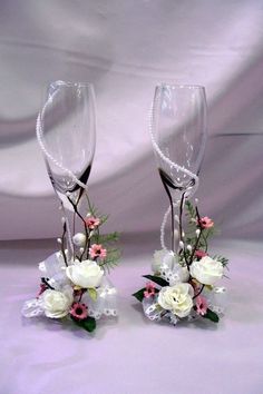 two wine glasses decorated with flowers and pearls