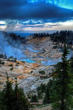 an image of a hot spring in the middle of the wilderness with trees around it